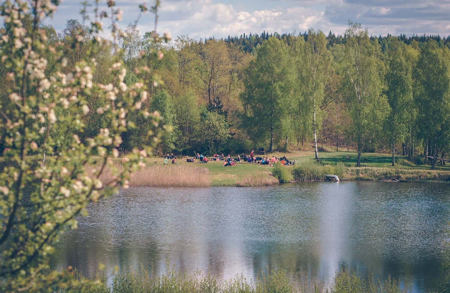 Människor samlade i det gröna landskapet vid en av sjöarna