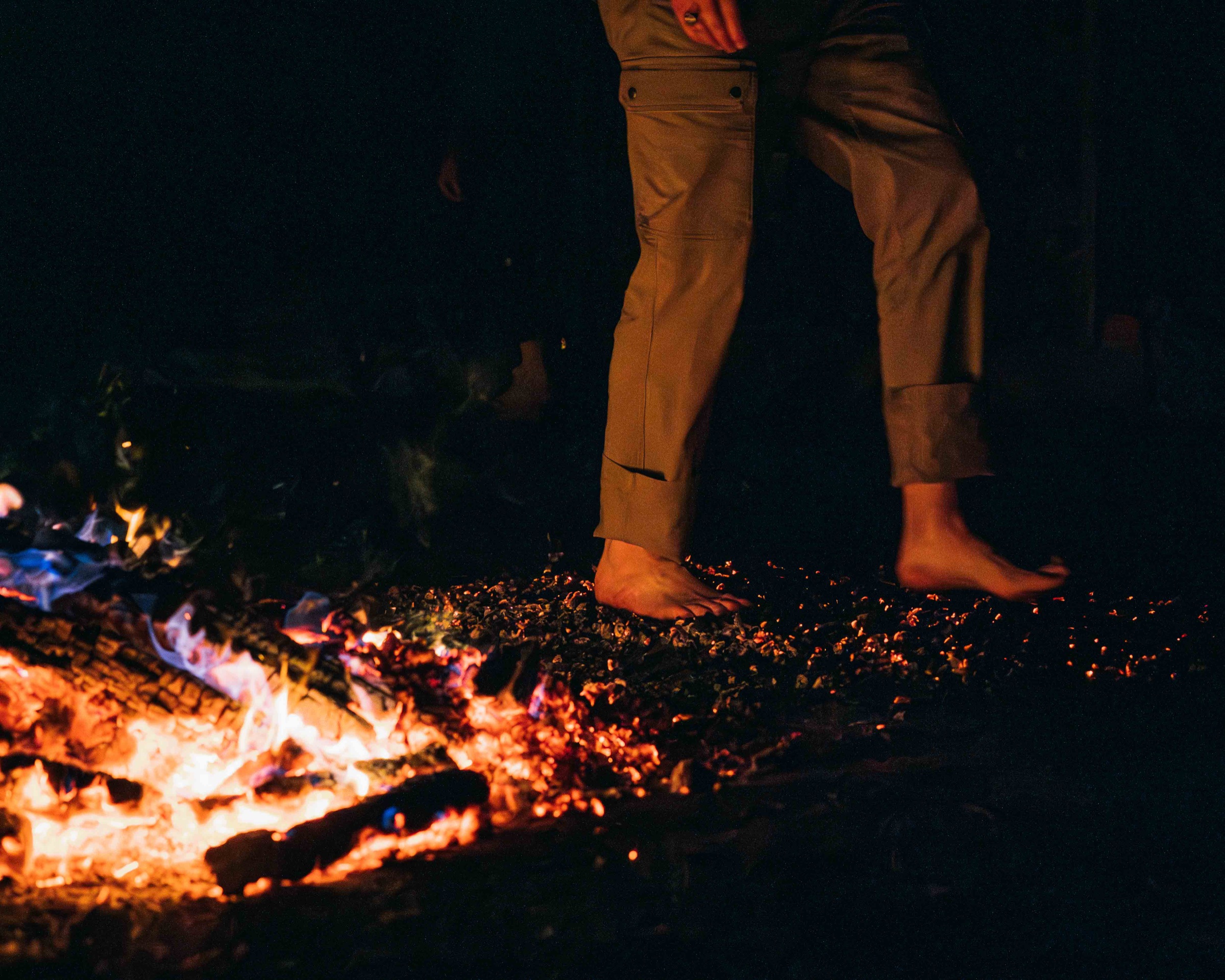 En person går barfota över glödande kol under Firewalk