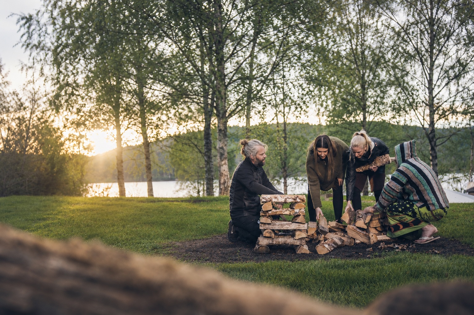 En grupp som samarbetar utomhus på gräset vid sjön
