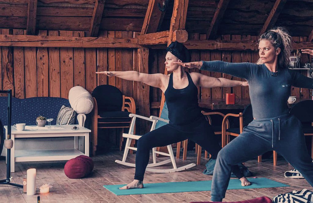 Deltagare som gör yoga tillsammans i en varm lokal