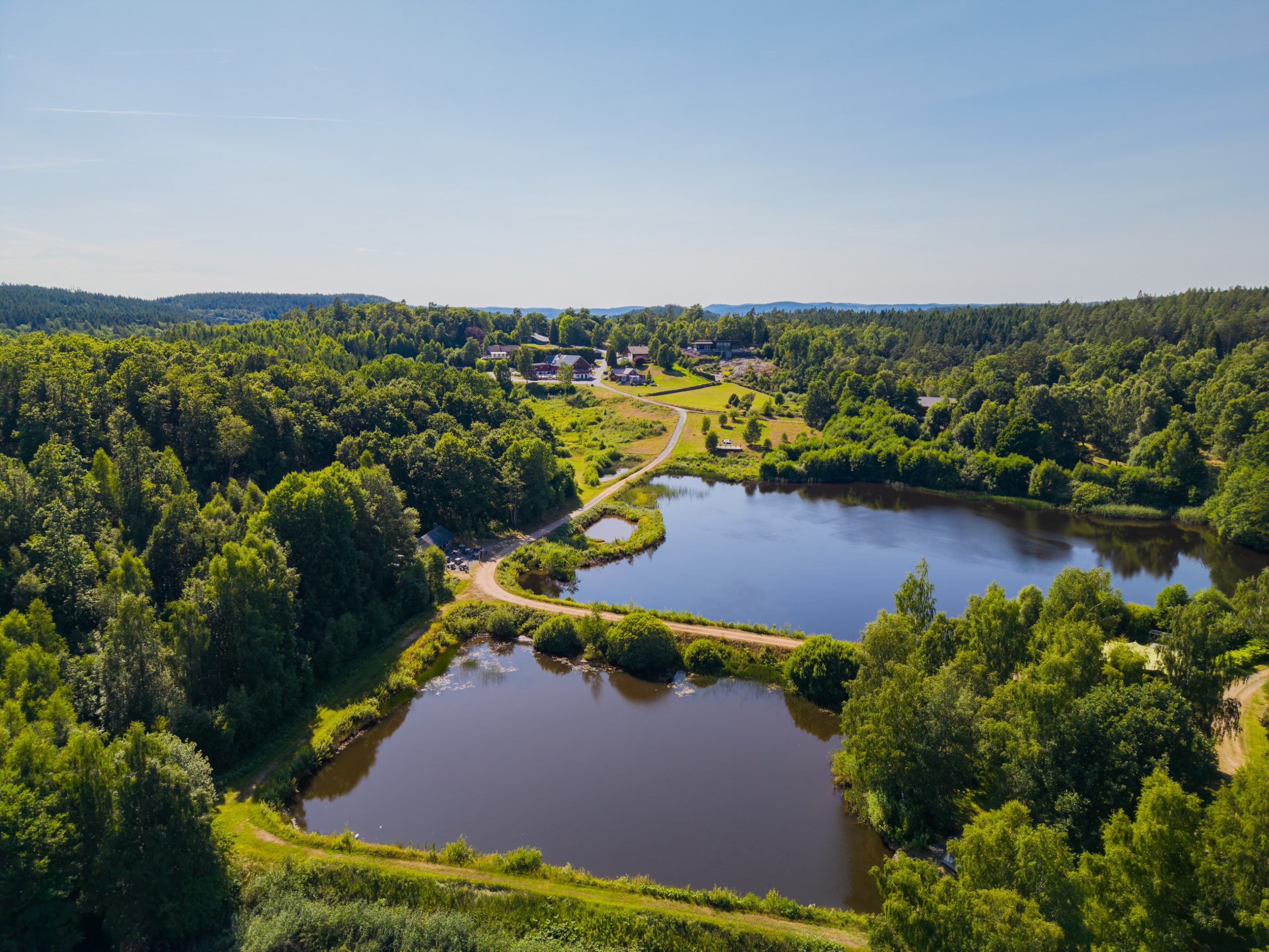 Drönarbild över sjöarna, skogen och gården på Sju Sjöar